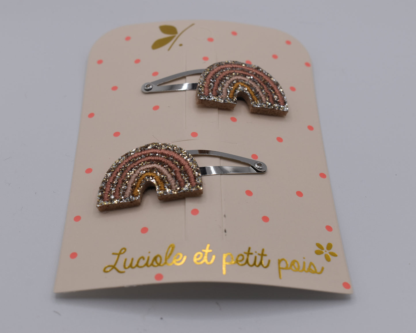 A set of beige glitter rainbow hair clip for girls. Front view. Made by Luciole et Petit Pois