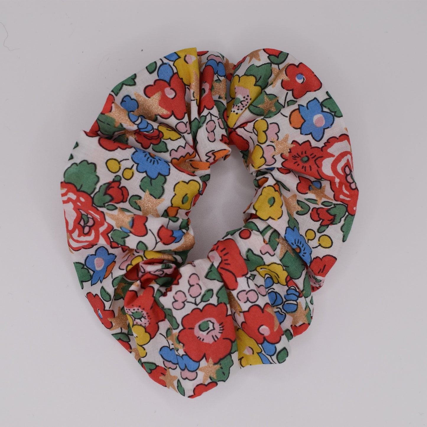A girls hair scrunchie made in Liberty fabric and Betsy Star White pattern. Made for girls by The Blossom Tree House. Top down view