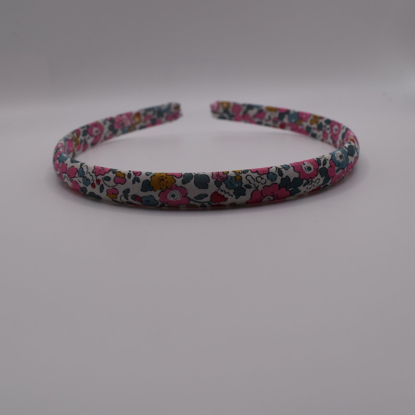 A girl's liberty print headband in Betsy Ann E. Front-on view. Made by The Blossom Tree House