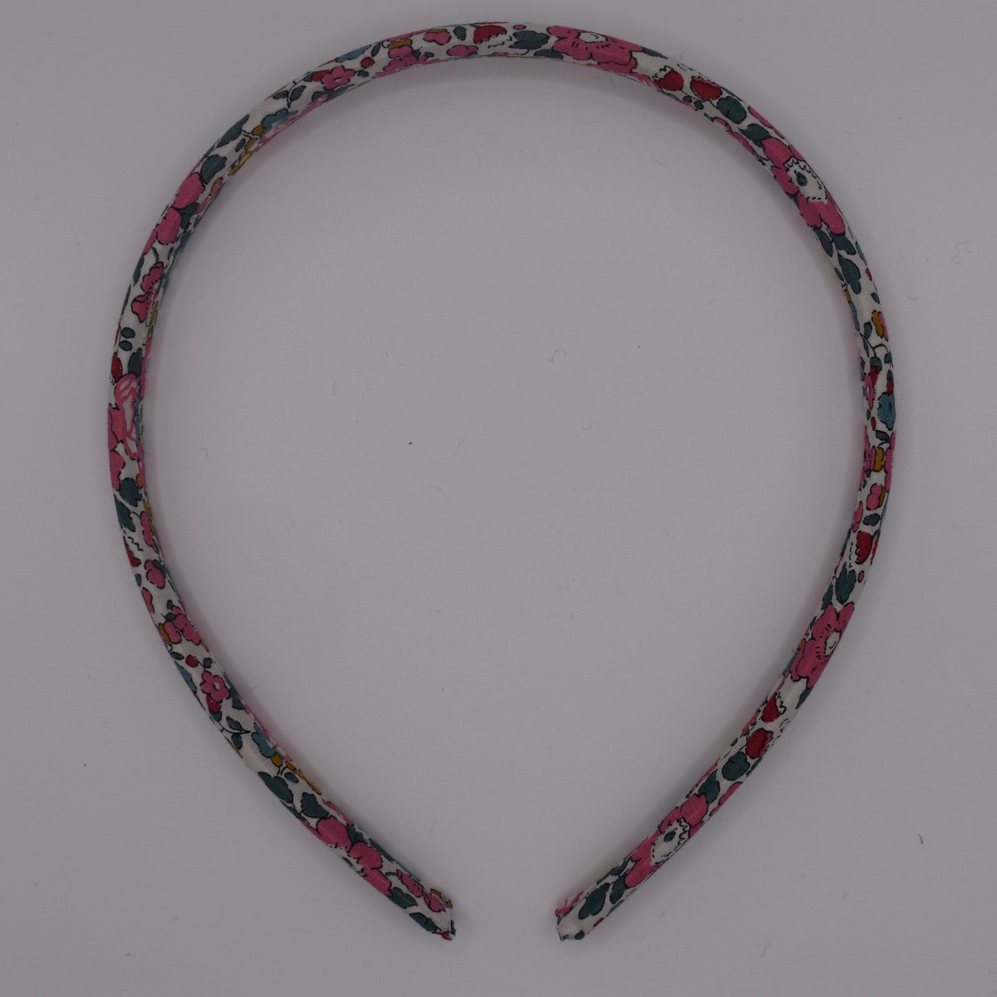 A girl's liberty print headband in Betsy Ann E. Top-down view. Made by The Blossom Tree House