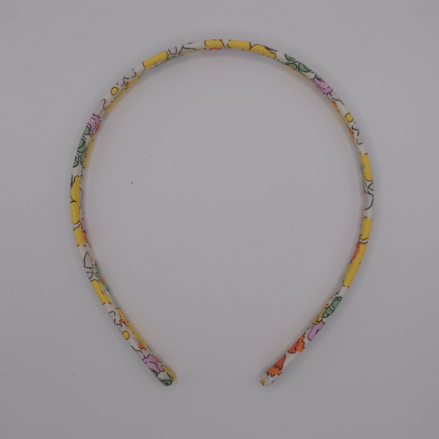 Liberty Headband for Girls in Betsy Yellow pattern. Handmade by The Blossom Tree House. Top down view