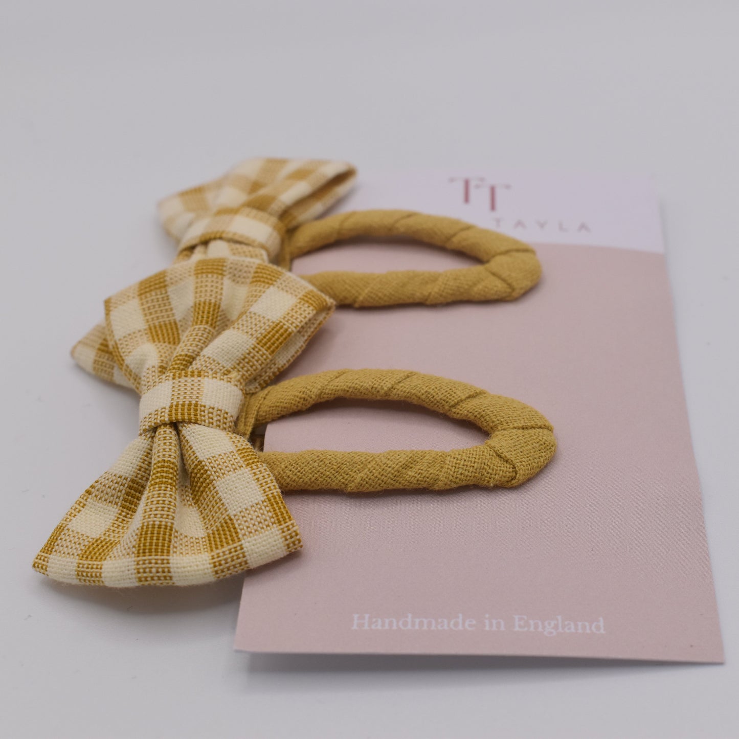 A set of yellow gingham bow hair clips for girls. Fabric material. Front view. Made by Tayla Tayla