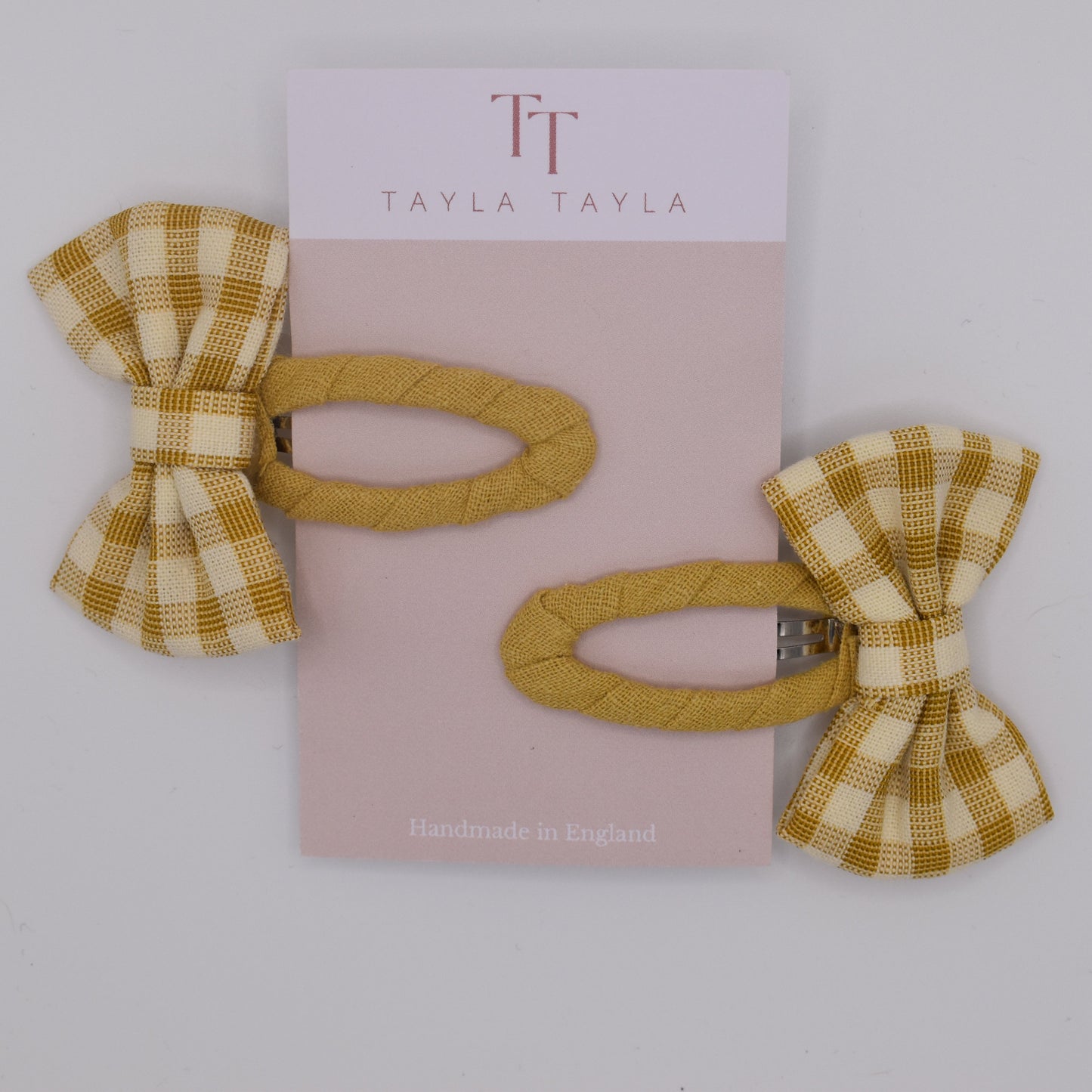 A set of yellow gingham bow hair clips for girls. Fabric material. Another top view. Made by Tayla Tayla