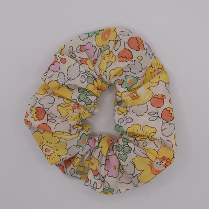 A Liberty hair scrunchie for girls using Betsy Yellow fabric. Made by The Blossom Tree House. Top down view