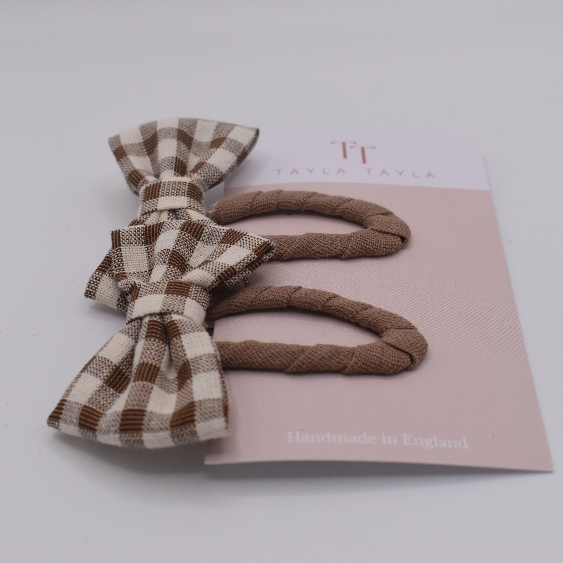A set of chocolate gingham bow hair clips for girls. Fabric material. Front view. Made by Tayla Tayla