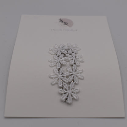 A daisy chain hair clip for girls. White fabric. Front view. Made by Studio Frommie