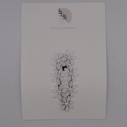 A daisy chain hair clip for girls. White fabric. Top view. Made by Studio Frommie