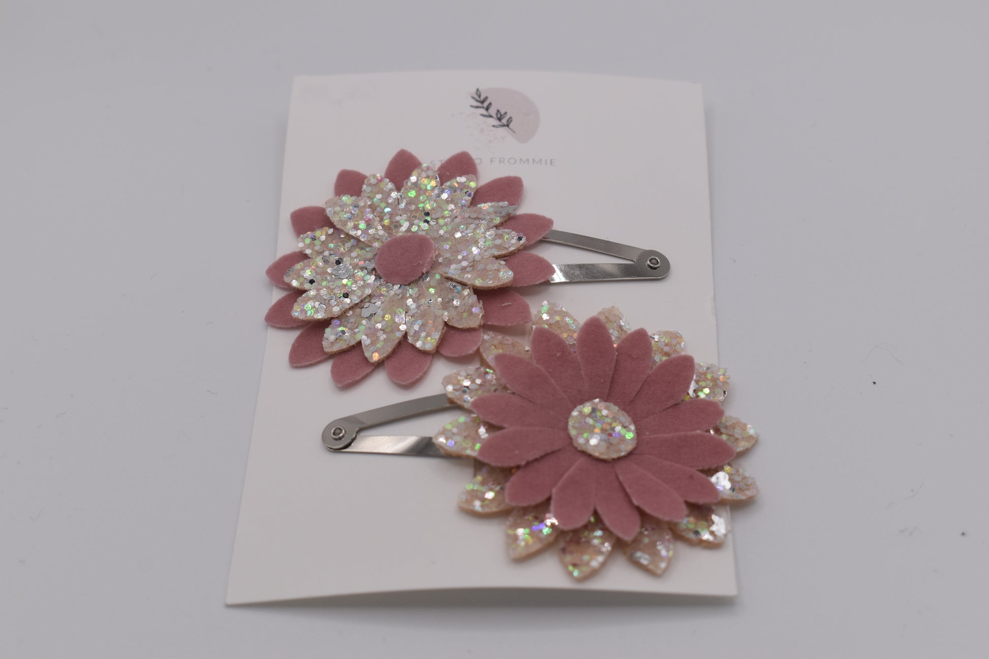 A glittery flower hair clip set for girls. Pink and silver colour. Front view. Made by Studio Frommie