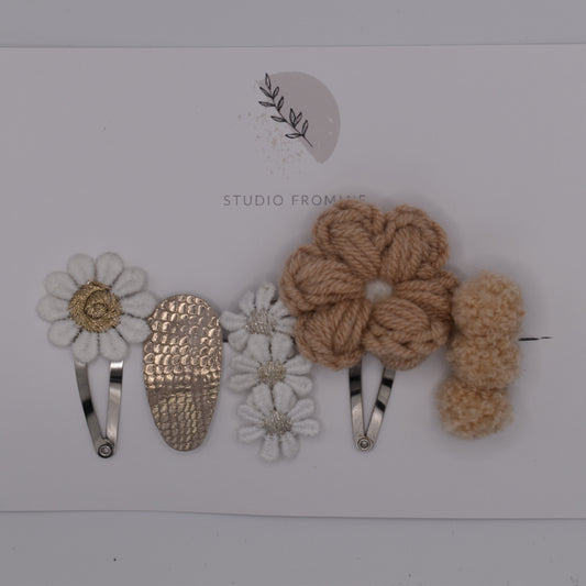 A flower and pompom hair clip set for girls. Beige and white colours. Top view. Made by Studio Frommie