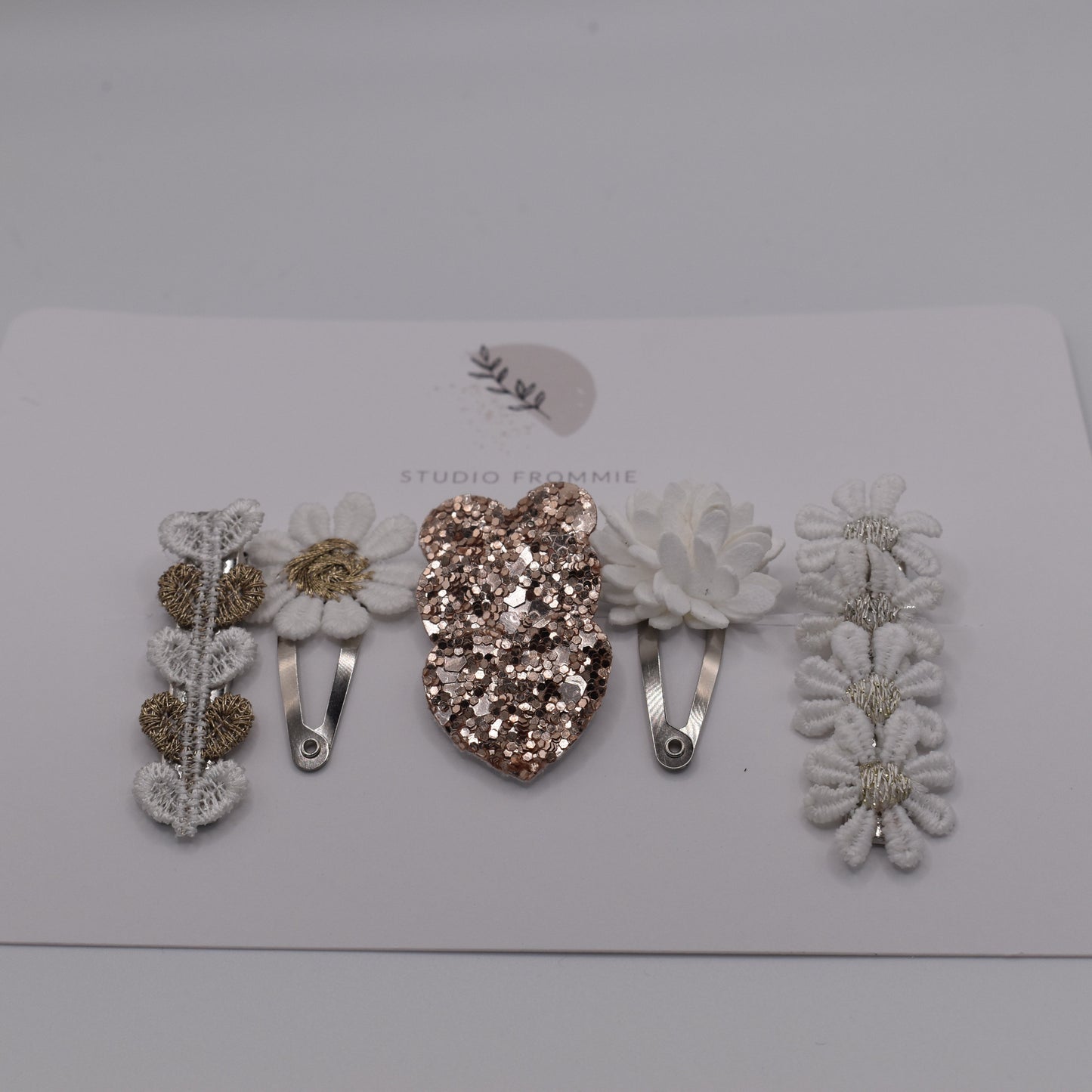 Hearts and daisies hair clip set for girls. White and sparkly gold colours. Front view. Made by Studio Frommie
