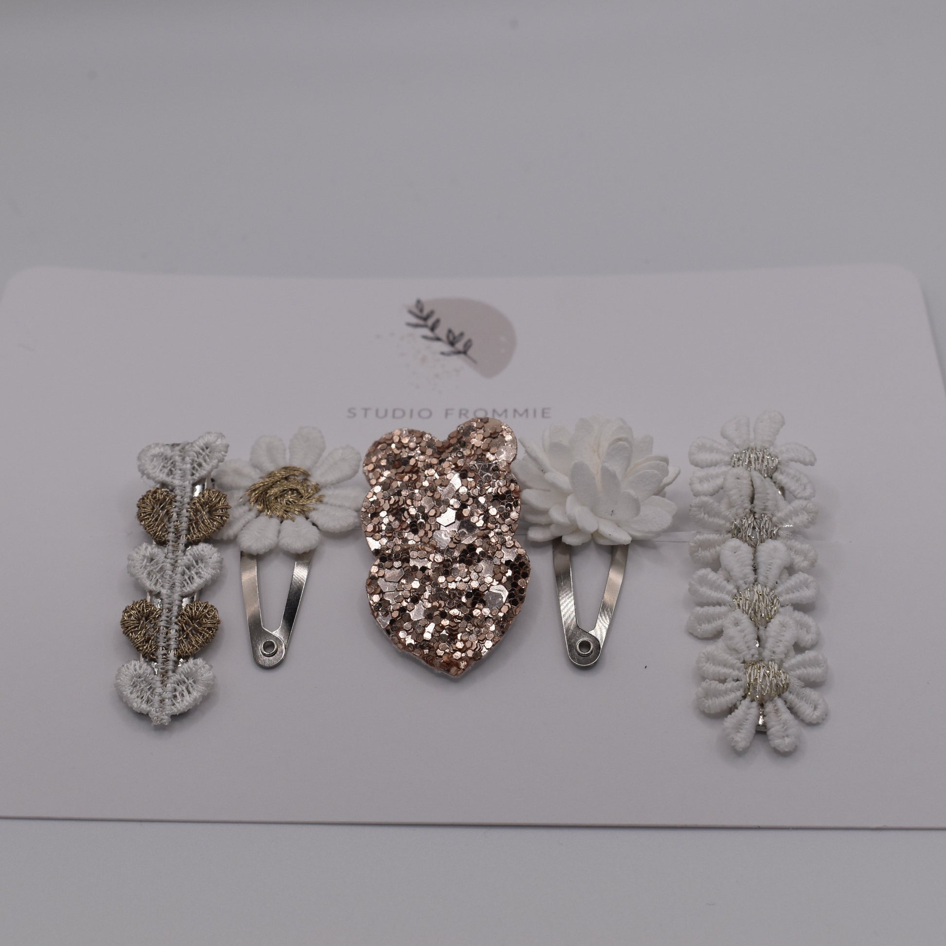Hearts and daisies hair clip set for girls. White and sparkly gold colours. Front view. Made by Studio Frommie