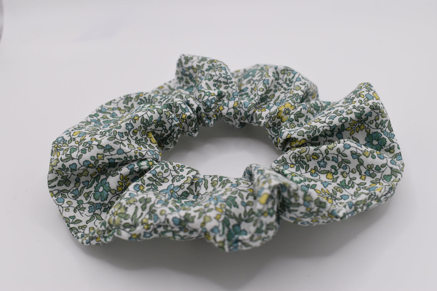 This is a Liberty of London hair scrunchie made by The Blossom Tree House in Katie and Millie Green cotton. Perfect for girls. Front view