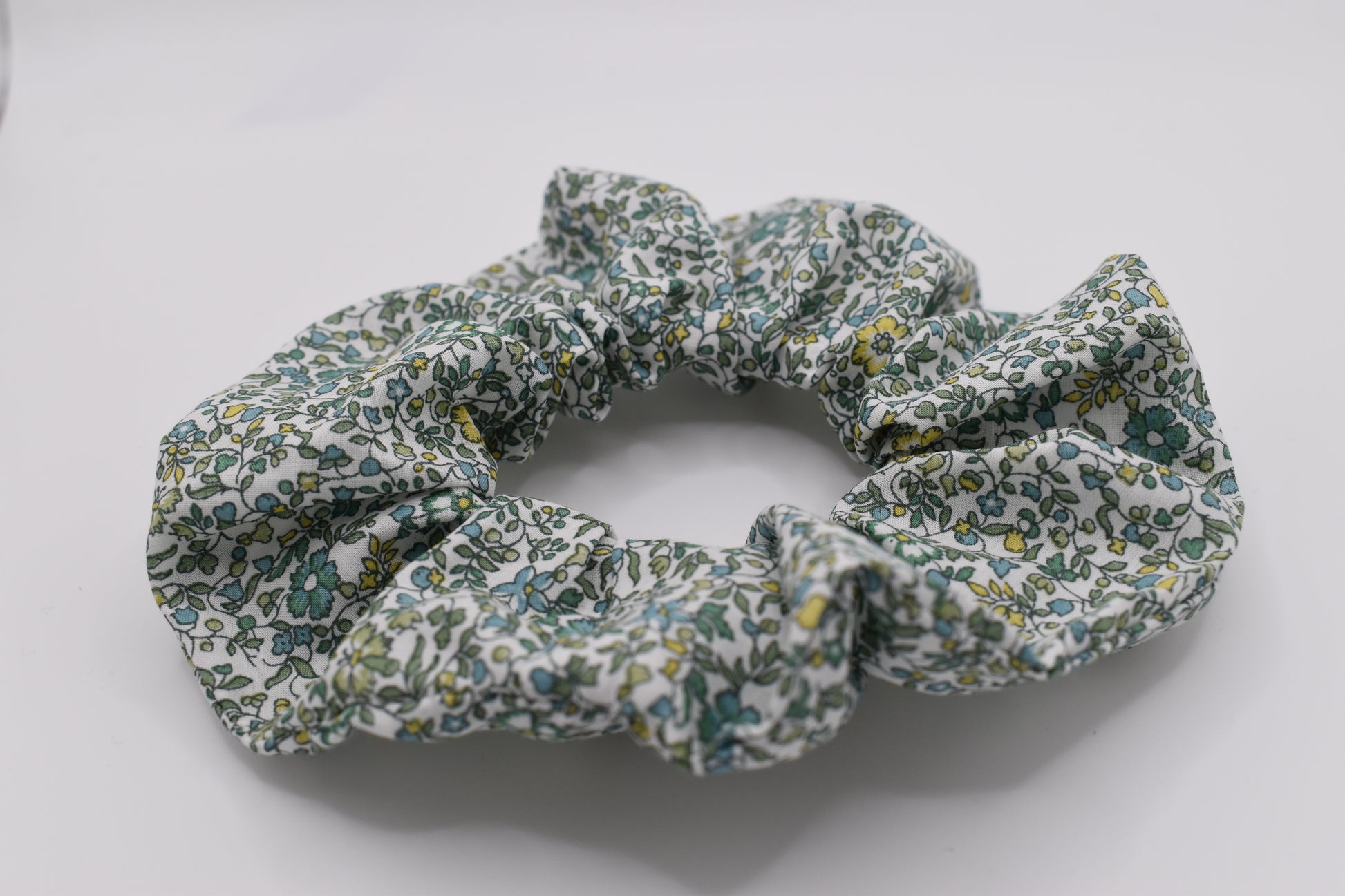 This is a Liberty of London hair scrunchie made by The Blossom Tree House in Katie and Millie Green cotton. Perfect for girls. Front view