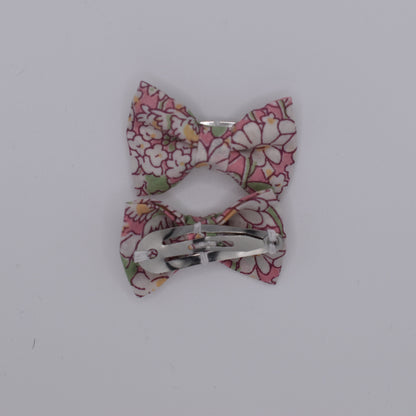 A pair of liberty bow hair clips in Alice Peach pattern. Floral design. Back view. Made by Luciole et Petit Pois
