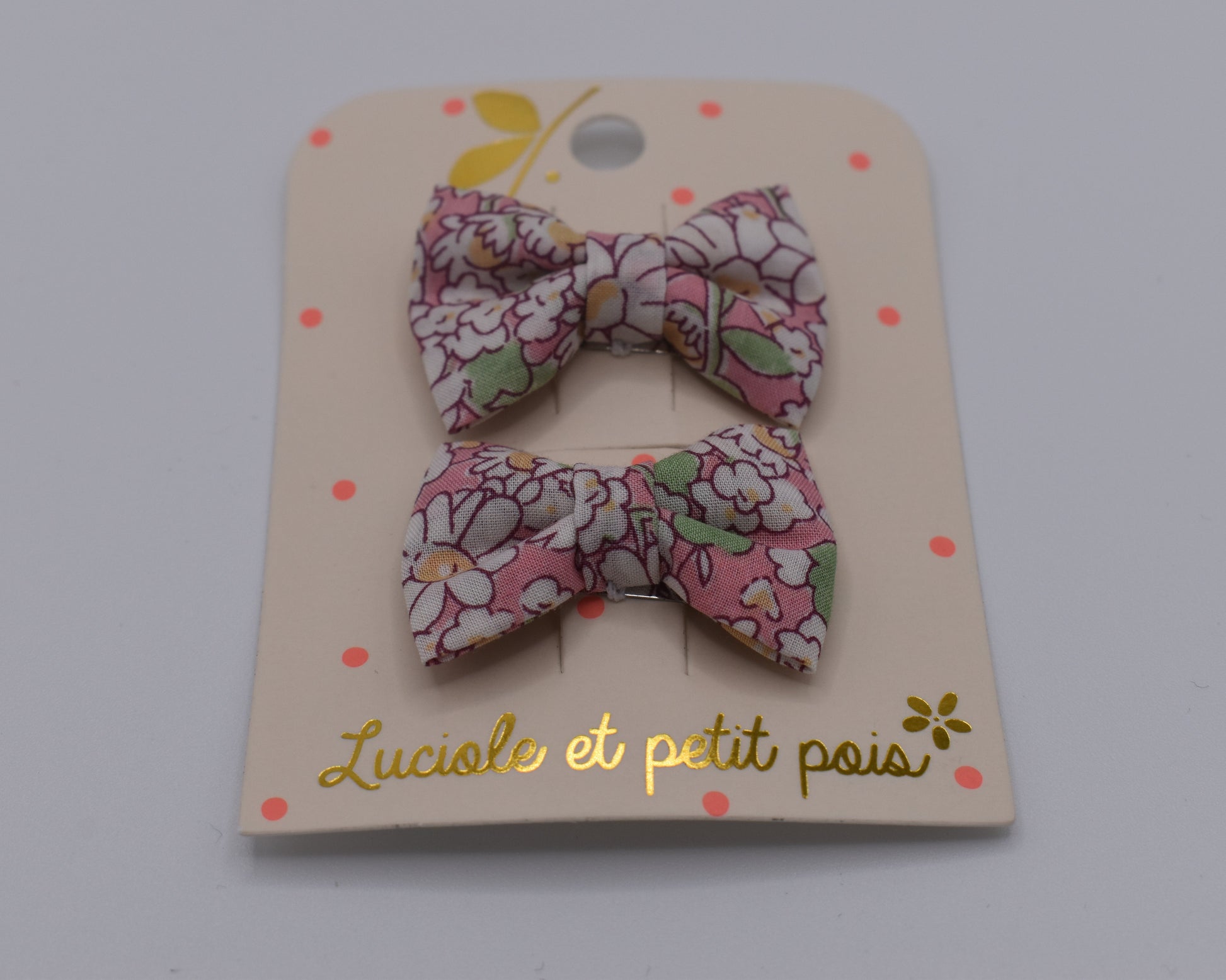 A pair of liberty bow hair clips in Alice Peach pattern. Floral design. Front view. Made by Luciole et Petit Pois