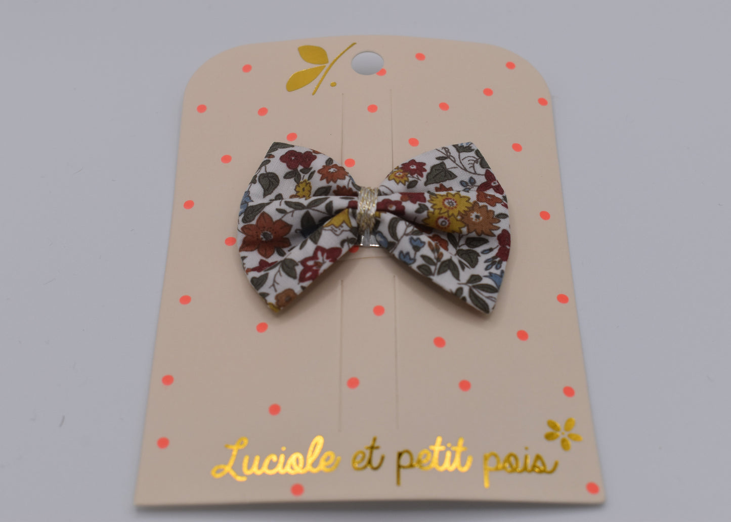 A liberty bow hair clip in Ava Autumn pattern. Floral pattern. Front view. Made by Luciole et Petit Pois