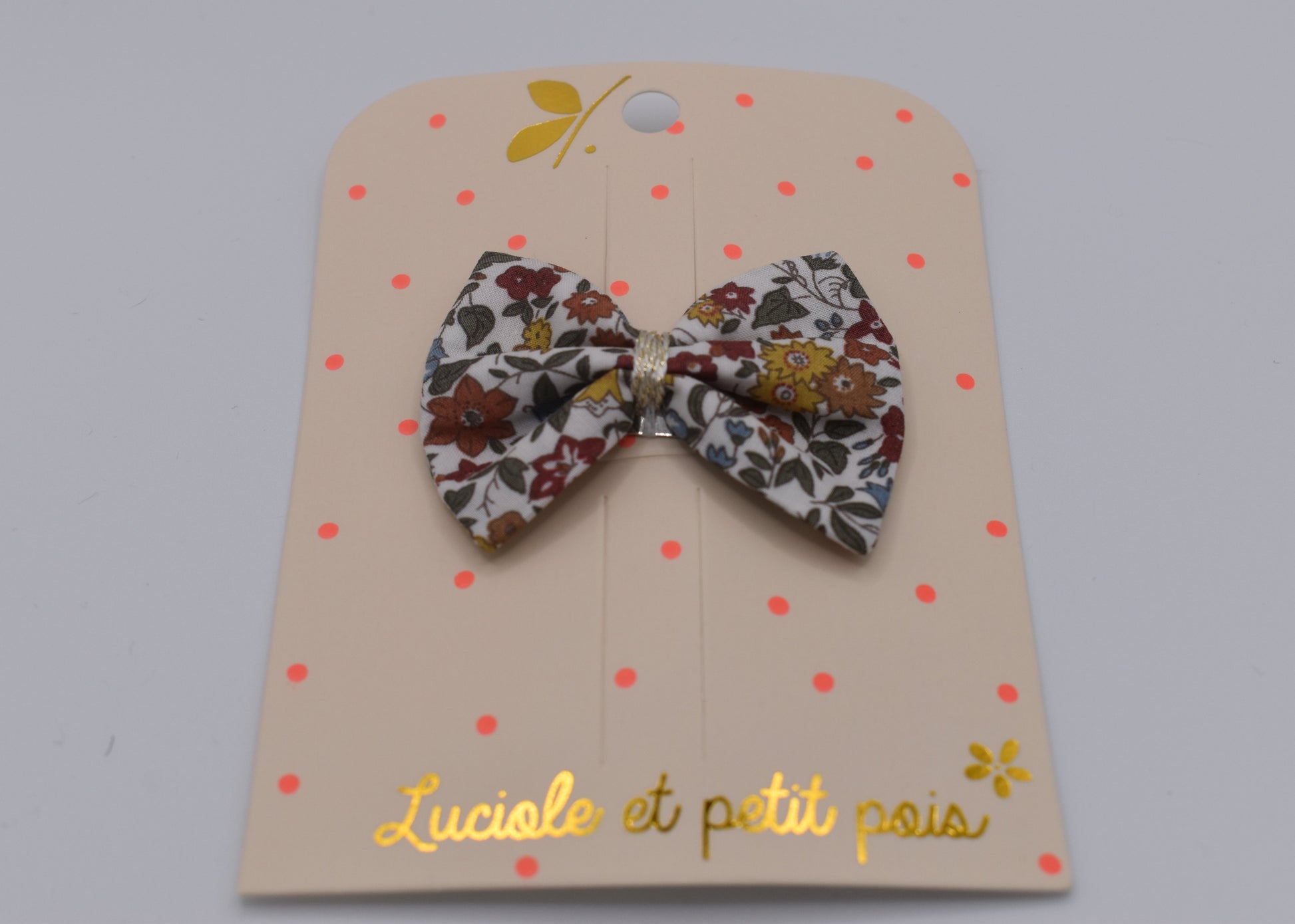 A liberty bow hair clip in Ava Autumn pattern. Floral pattern. Front view. Made by Luciole et Petit Pois