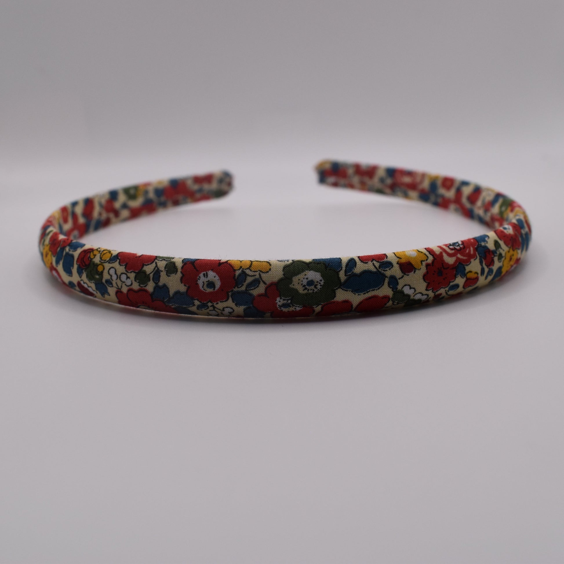 A girl's liberty print headband in Betsy Ann B Red. Front-on view. Made by The Blossom Tree House
