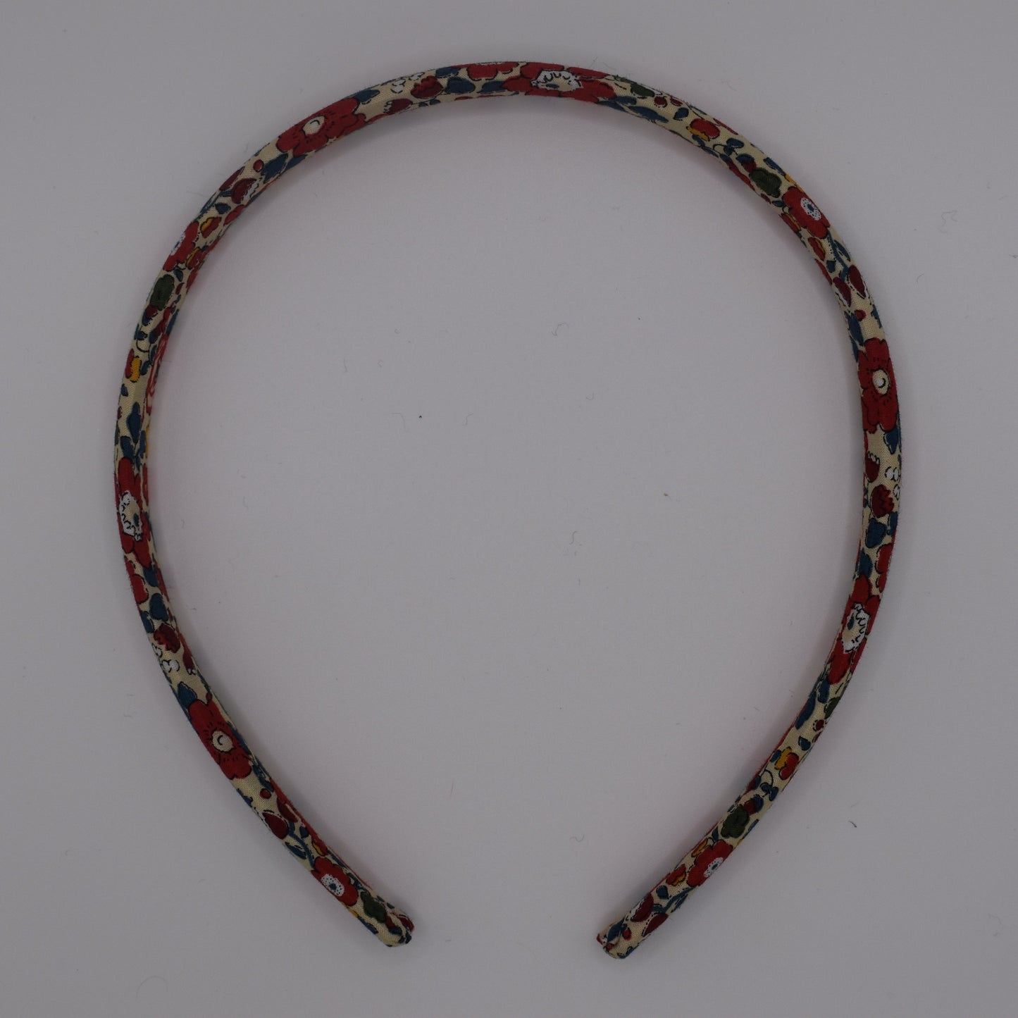 A girl's liberty print headband in Betsy Ann B Red. Top-down view. Made by The Blossom Tree House