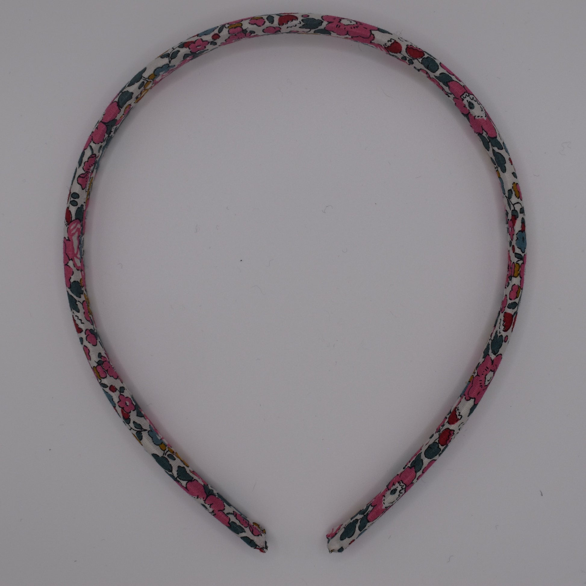 A girl's liberty print headband in Betsy Ann E. Top-down view. Made by The Blossom Tree House