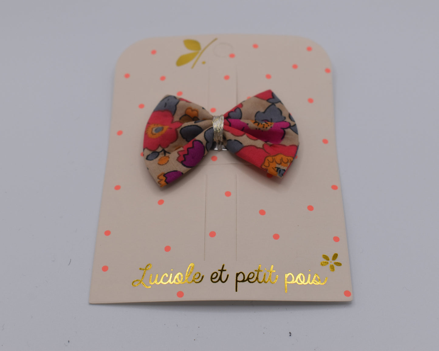 A liberty bow hair clip in Betsy Fluo Tea pattern. Front view. Made by Luciole et Petit Pois