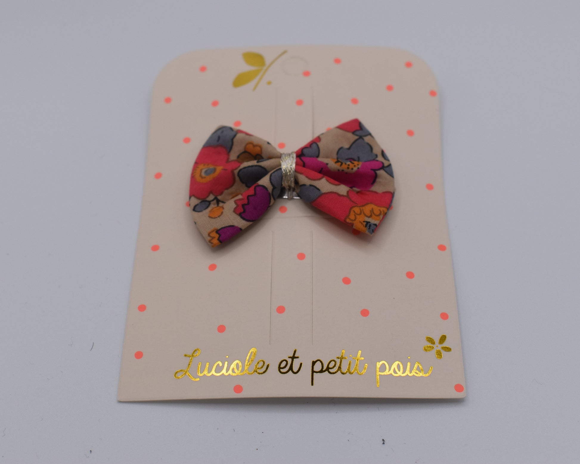 A liberty bow hair clip in Betsy Fluo Tea pattern. Front view. Made by Luciole et Petit Pois