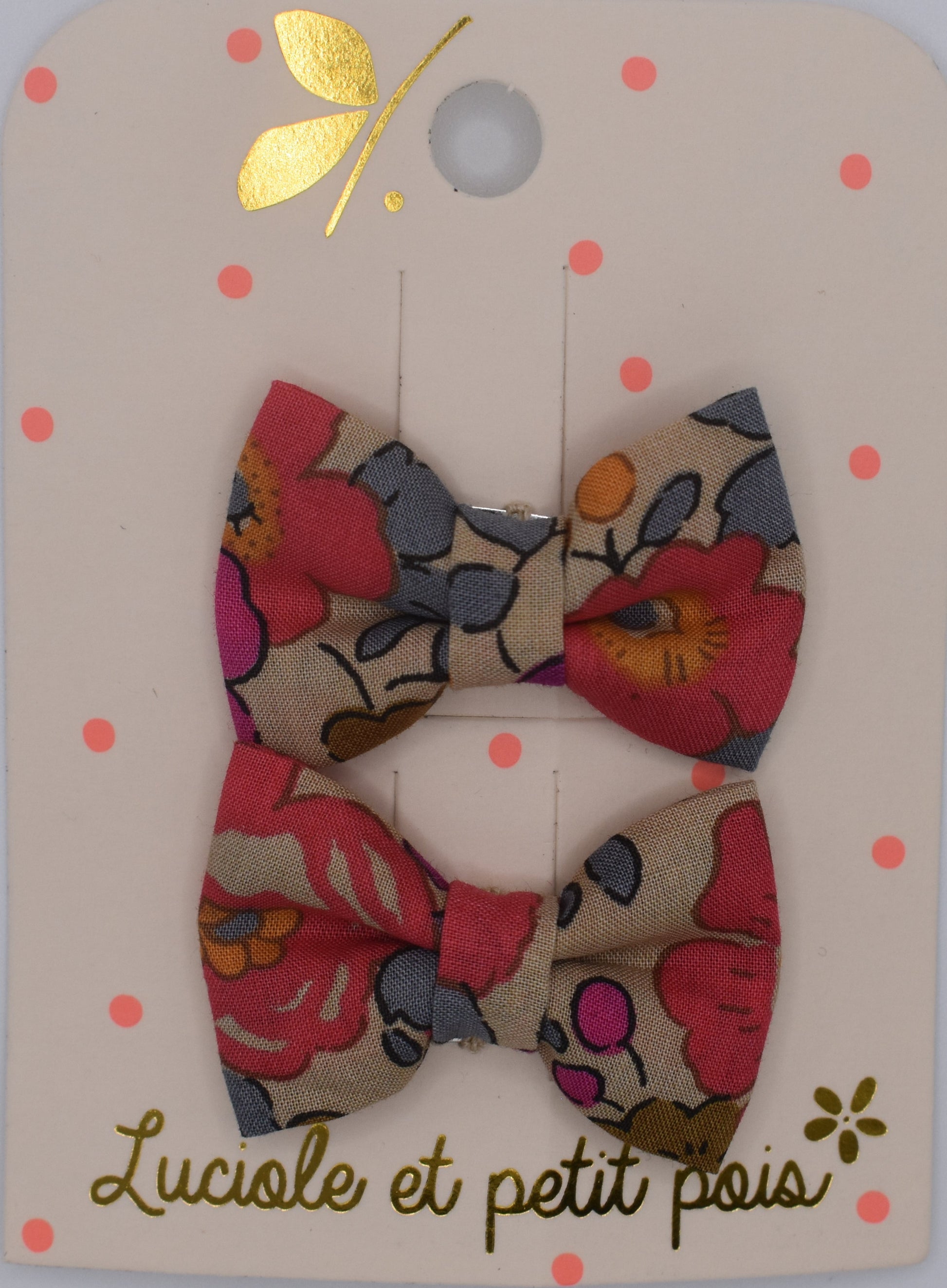 A pair of mini liberty bow hair clips for girls in Betsy Fluo Tea pattern. Top view. Made by Luciole et Petit Pois
