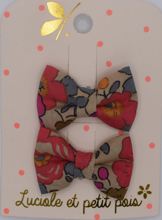 A pair of mini liberty bow hair clips for girls in Betsy Fluo Tea pattern. Top view. Made by Luciole et Petit Pois