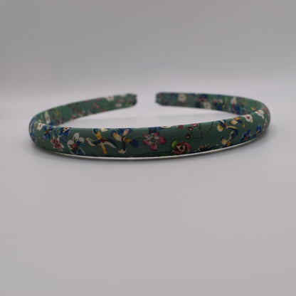 A girl's liberty print headband in Donna Leigh Green. Front-on view. Made by The Blossom Tree House