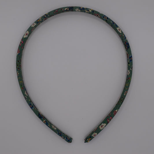 A girl's liberty print headband in Donna Leigh Green. Top-down view. Made by The Blossom Tree House