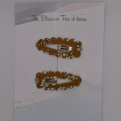 A barrette hair clip with a Liberty print design in Mustard Capel. Top-down view. Made by The Blossom Tree House