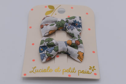 A pair of mini liberty bow hair clips for girls in Nancy Ann Clementine pattern. Front view. Made by Luciole et Petit Pois
