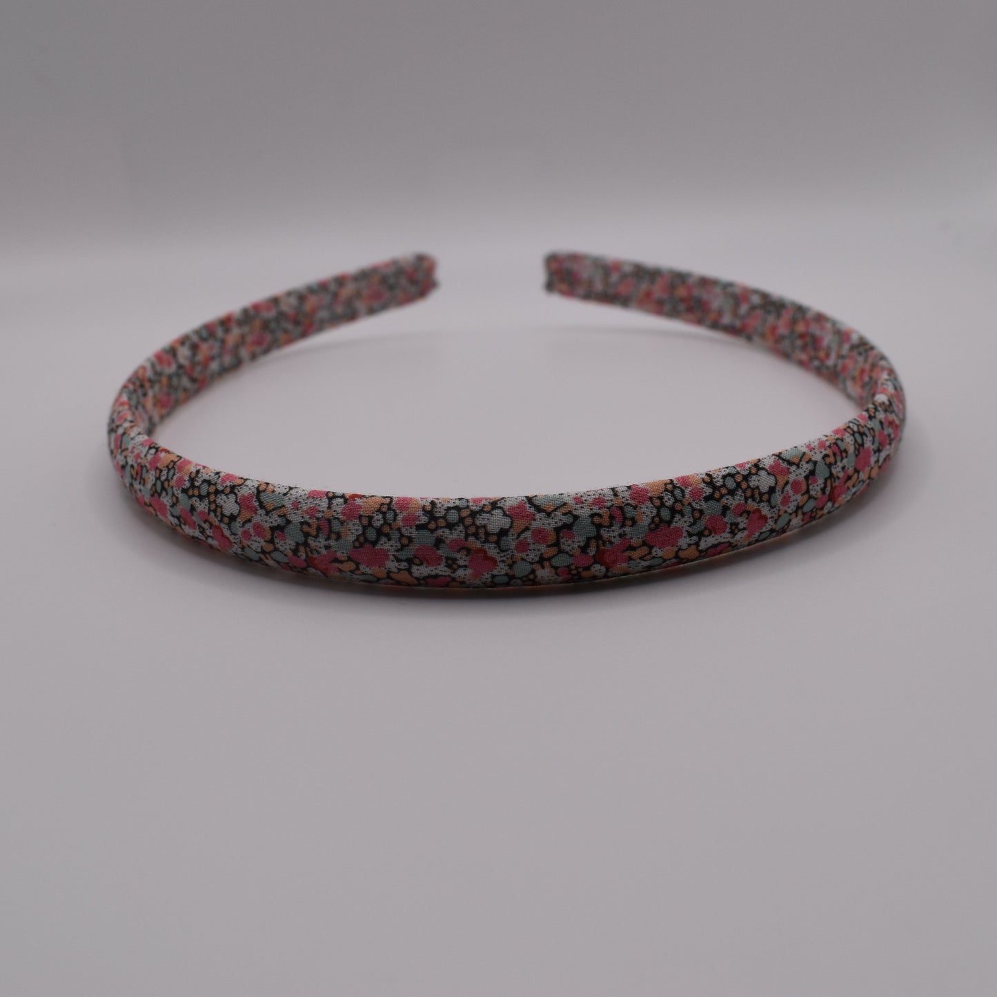 A girl's liberty print headband in Pink Pepper. Front-on view. Made by The Blossom Tree House