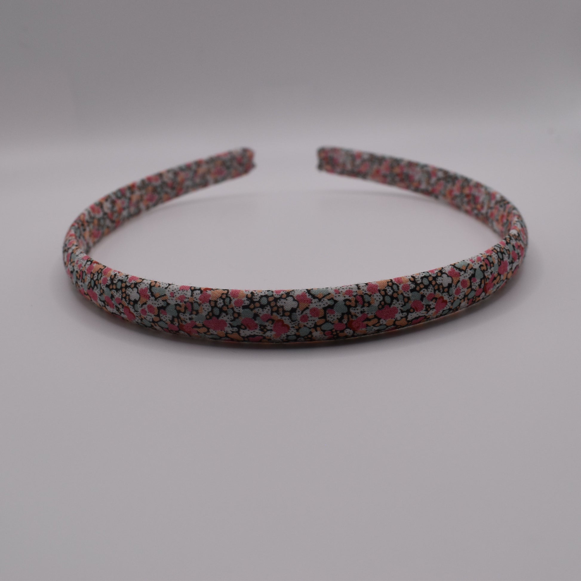 A girl's liberty print headband in Pink Pepper. Front-on view. Made by The Blossom Tree House