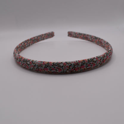 A girl's liberty print headband in Pink Pepper. Front-on view. Made by The Blossom Tree House