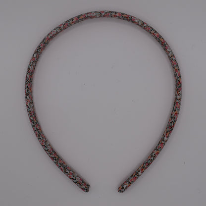 A girl's liberty print headband in Pink Pepper. Top-down view. Made by The Blossom Tree House