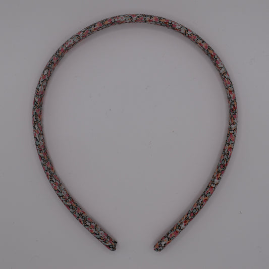 A girl's liberty print headband in Pink Pepper. Top-down view. Made by The Blossom Tree House