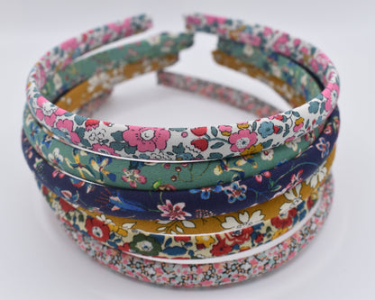 A stack of numerous Liberty Print Headbands from a front-on view. Made by The Blossom Tree House