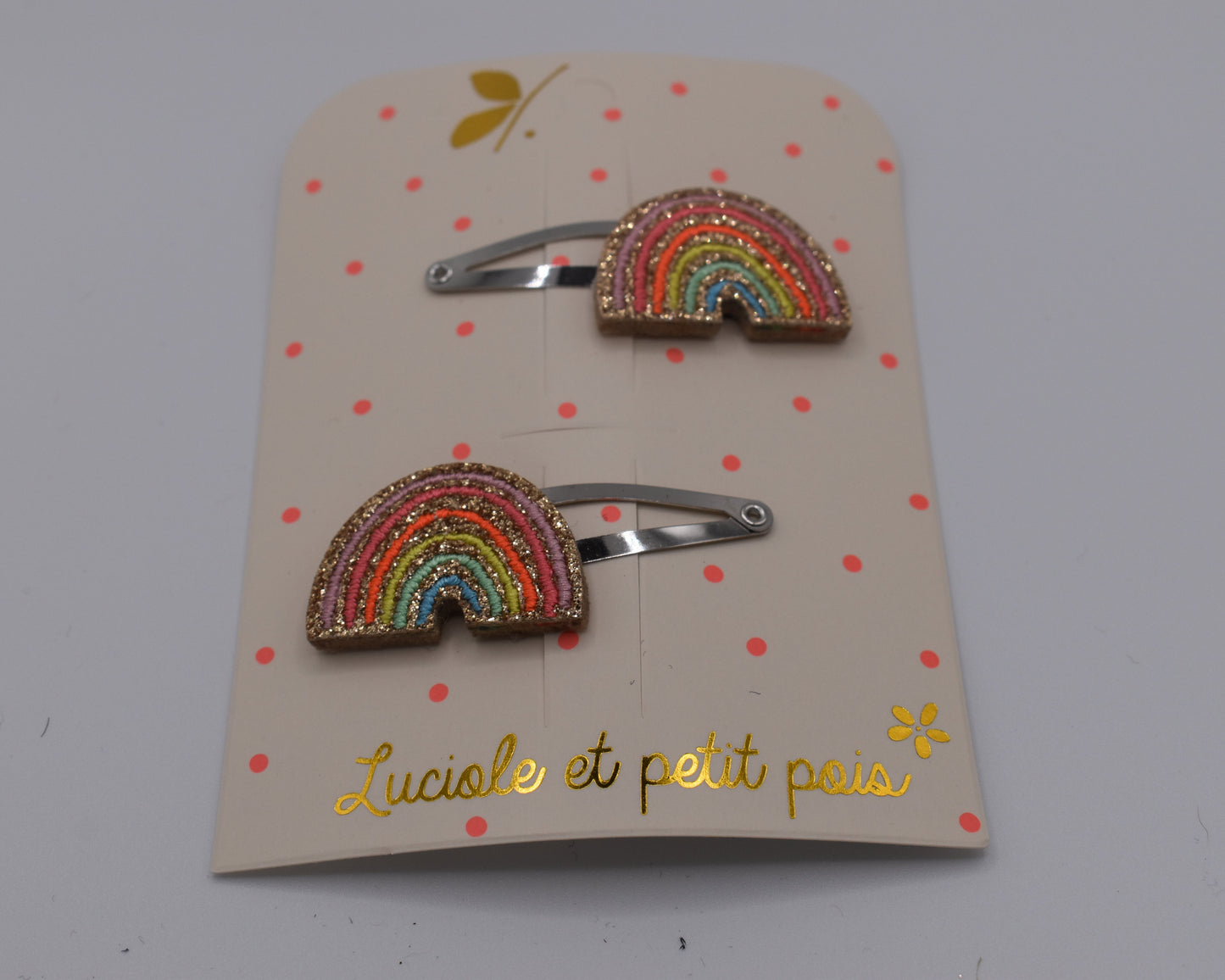 A pair of multicoloured rainbow hair clips for girls. Glittery. Front view. Made by Luciole et Petit Pois
