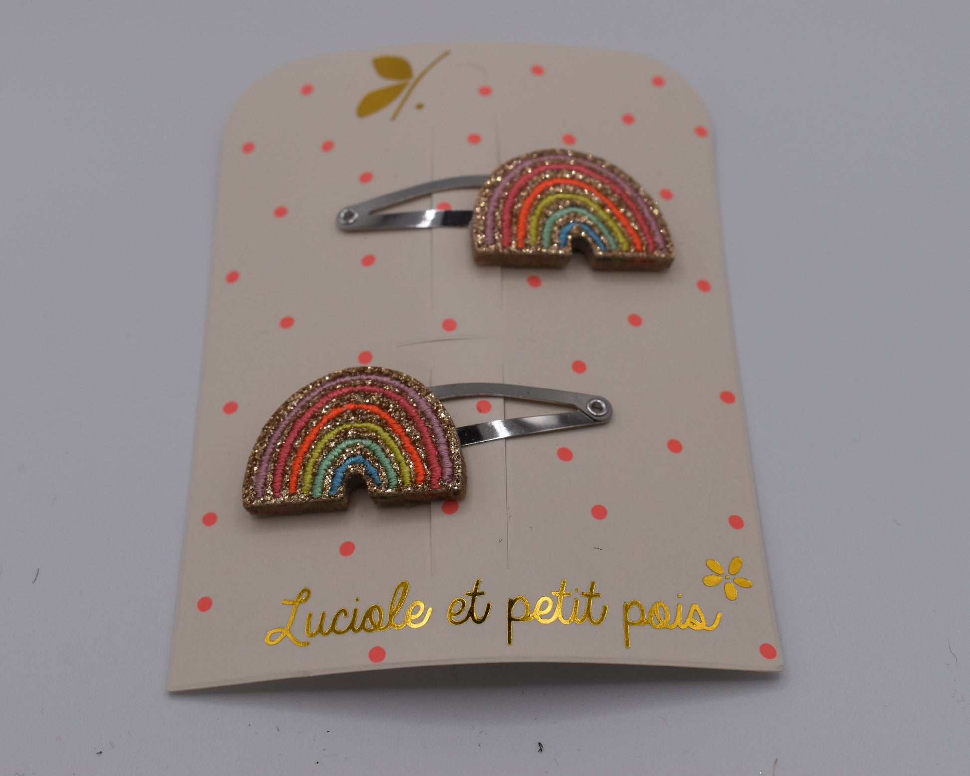 A pair of multicoloured rainbow hair clips for girls. Glittery. Front view. Made by Luciole et Petit Pois