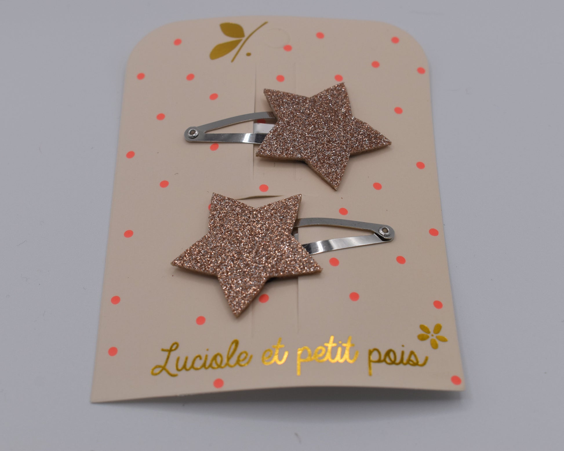 A pair of glitter star hair clips for girls. Pink colour. Front view. Made by Luciole et Petit Pois