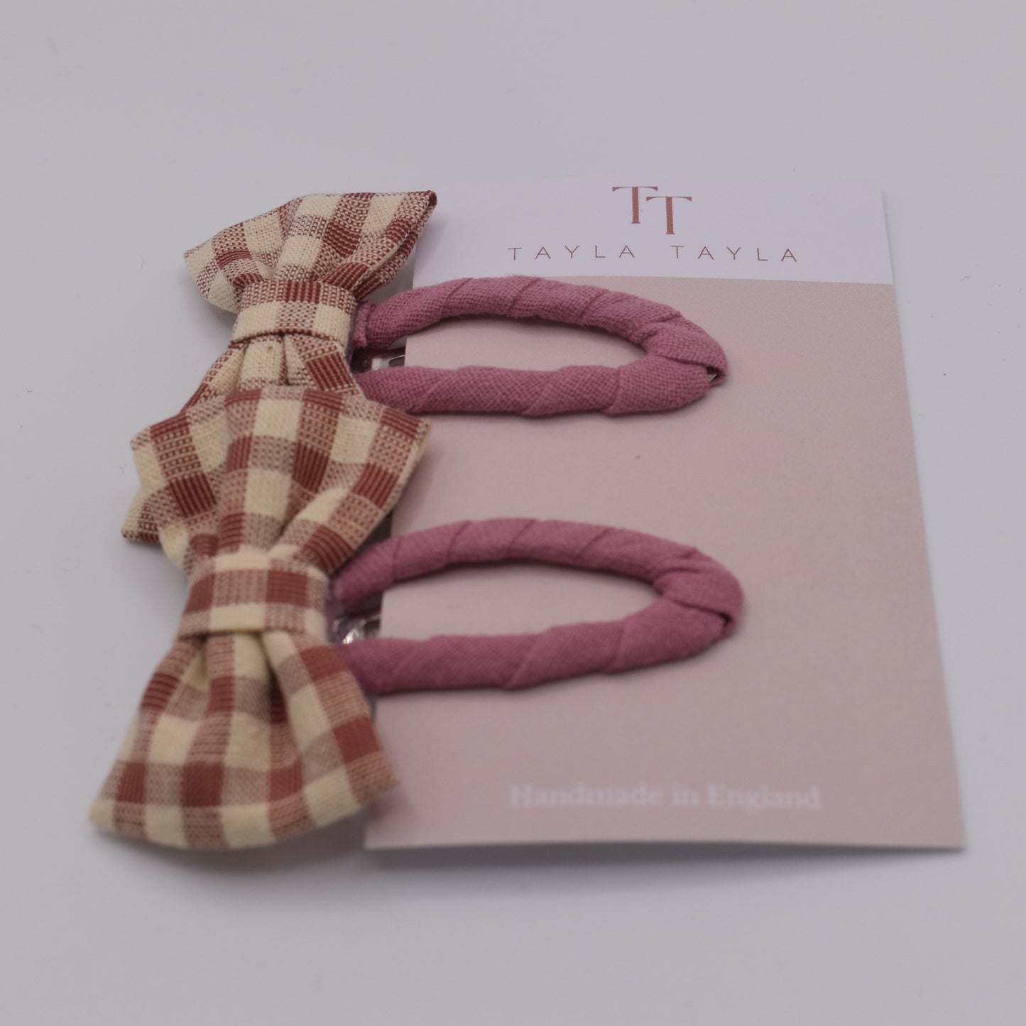 A set of pink gingham bow hair clips for girls. Fabric material. Front view. Made by Tayla Tayla