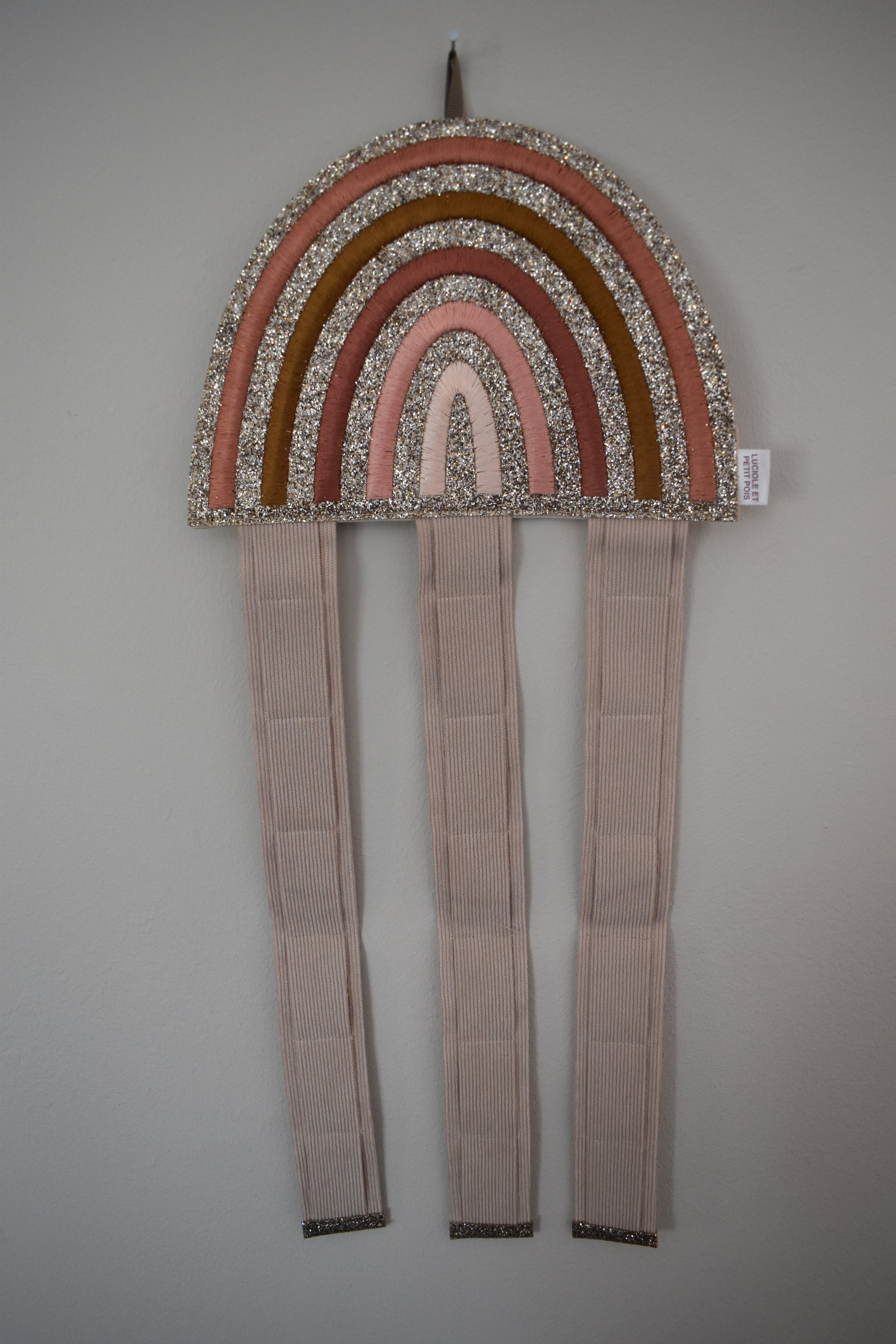 A rainbow hair clip holder. Glittery and wall hanging. Perfect for storage of girls hair clips. Front view