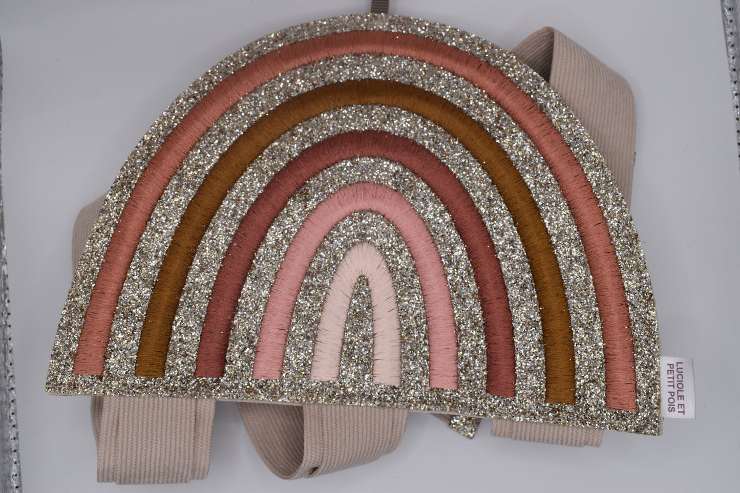 A rainbow hair clip holder. Glittery and wall hanging. Perfect for storage of girls hair clips. Top view of holder folded up 