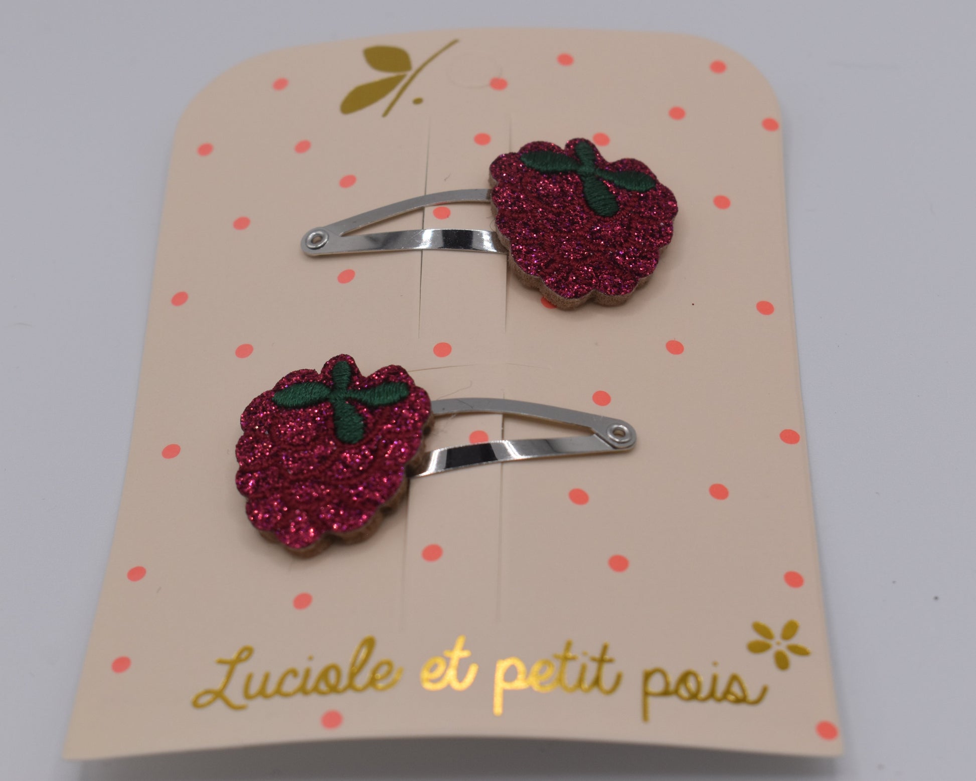 A pair of glitter raspberry hair clips for girls. Red colour. Front view. Made by Luciole et Petit Pois