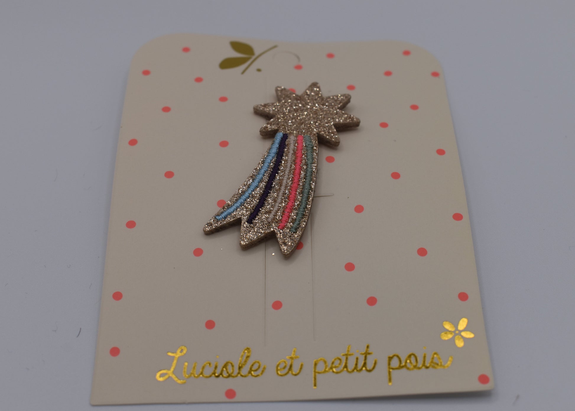 A glitter shooting star hair clip for girls. Pink and multicoloured. Front view. Made by Luciole et Petit Pois