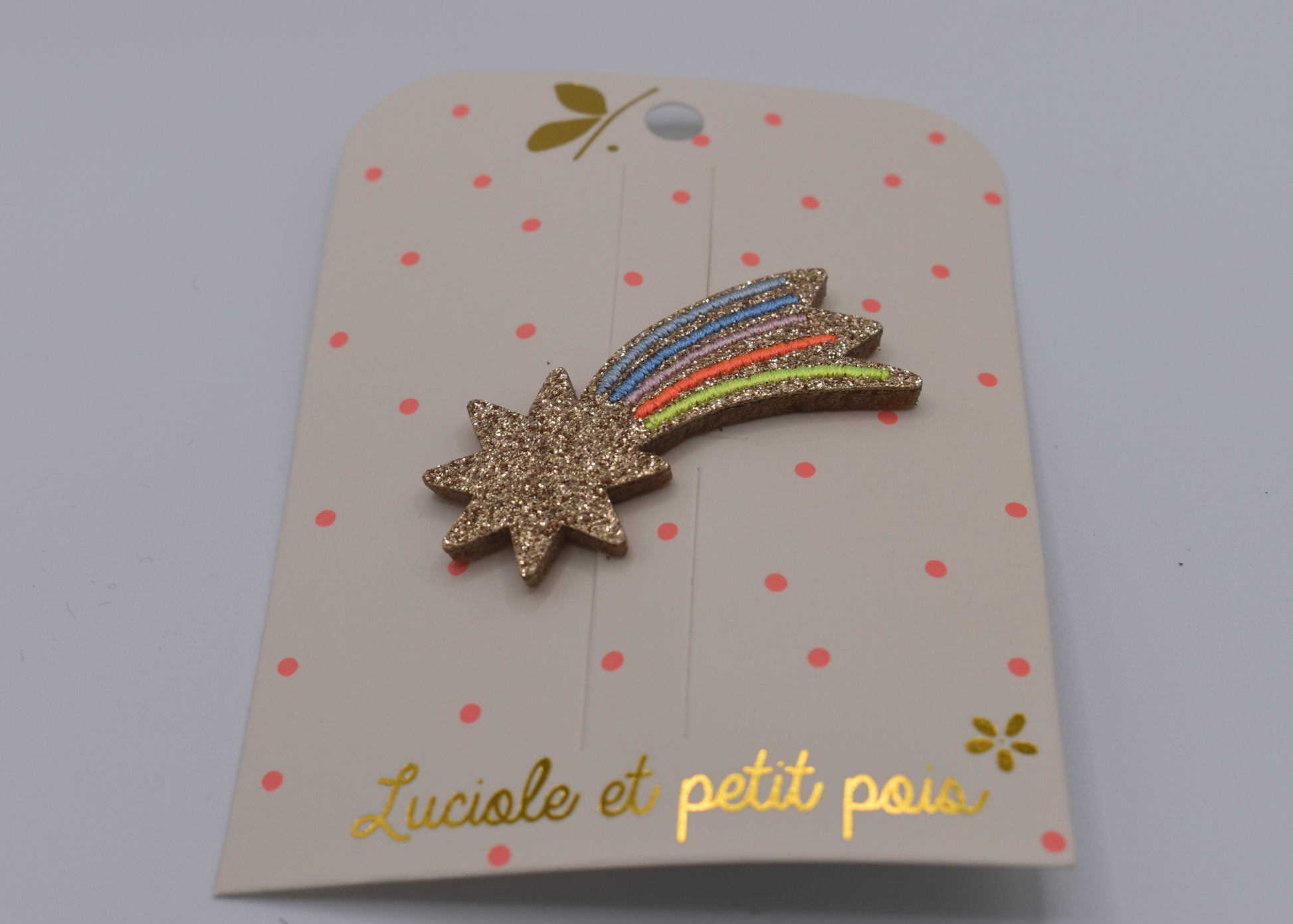 A glitter shooting star hair clip for girls. Multicoloured. Front view. Made by Luciole et Petit Pois