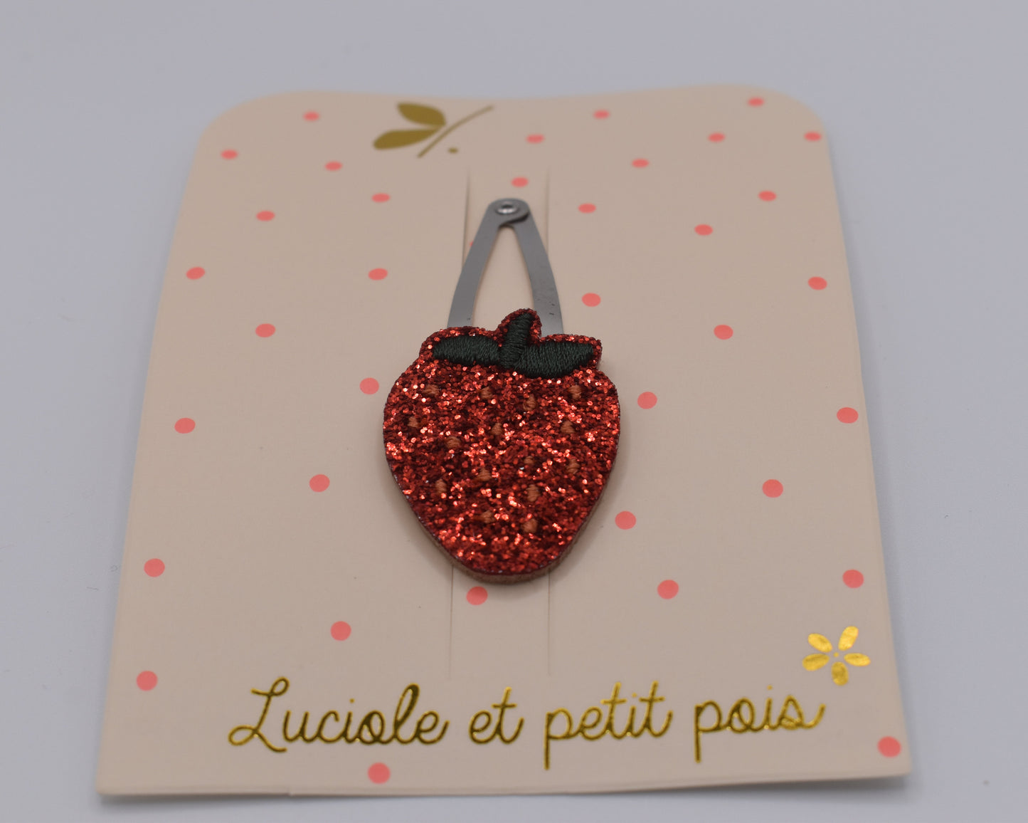 A glitter strawberry hair clip for girls. Red colour. Front view. Made by Luciole et Petit Pois
