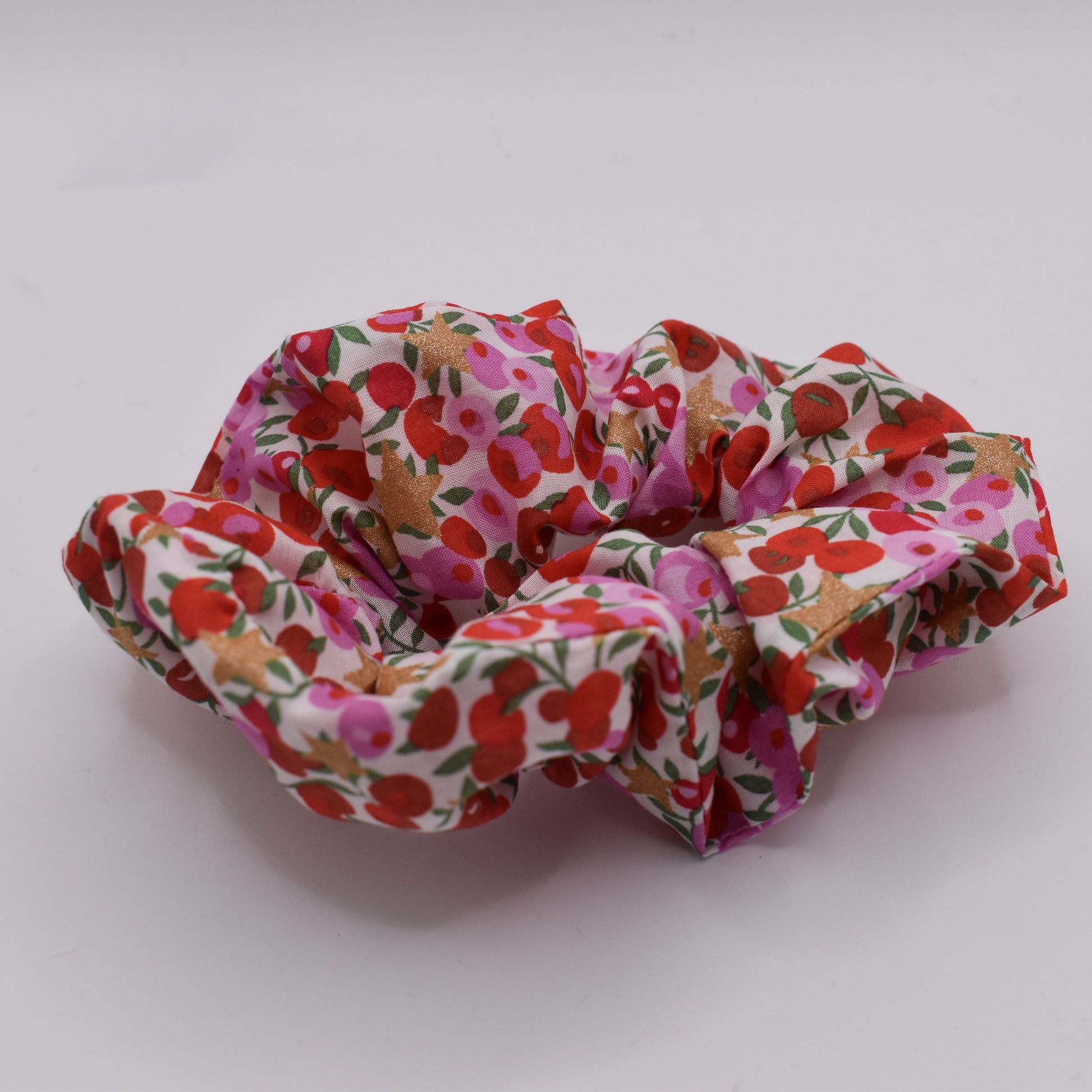 A Liberty print hair scrunchie for girls using Wiltshire Star Pink fabric and pattern. Front on view