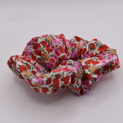A Liberty print hair scrunchie for girls using Wiltshire Star Pink fabric and pattern. Front on view